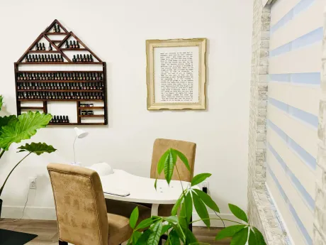 The nail station with a light table, velvet chairs and the polish wall behind